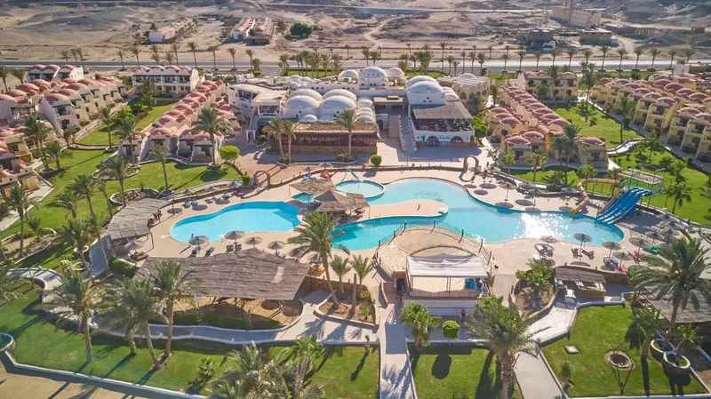 Vue aérienne d'un complexe hôtelier avec piscines et végétation luxuriante.