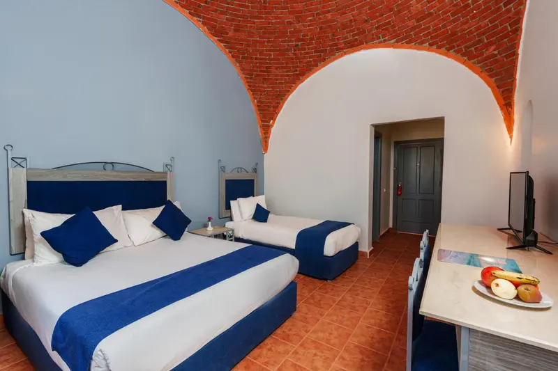 Chambre avec deux lits simples et une décoration bleue.