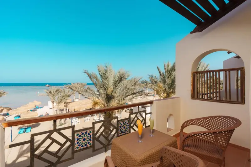 Une terrasse ensoleillée offre une vue sur la mer et la végétation.
