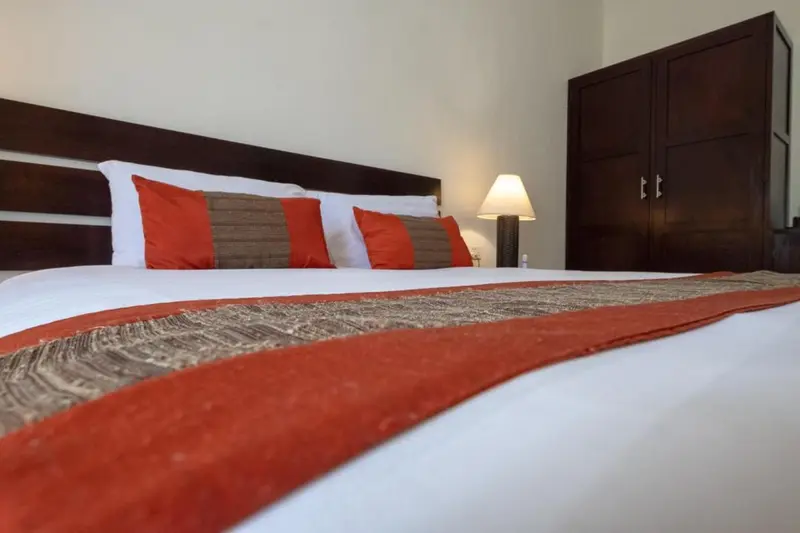 Un lit recouvert d'une courtepointe et de coussins colorés dans une chambre.