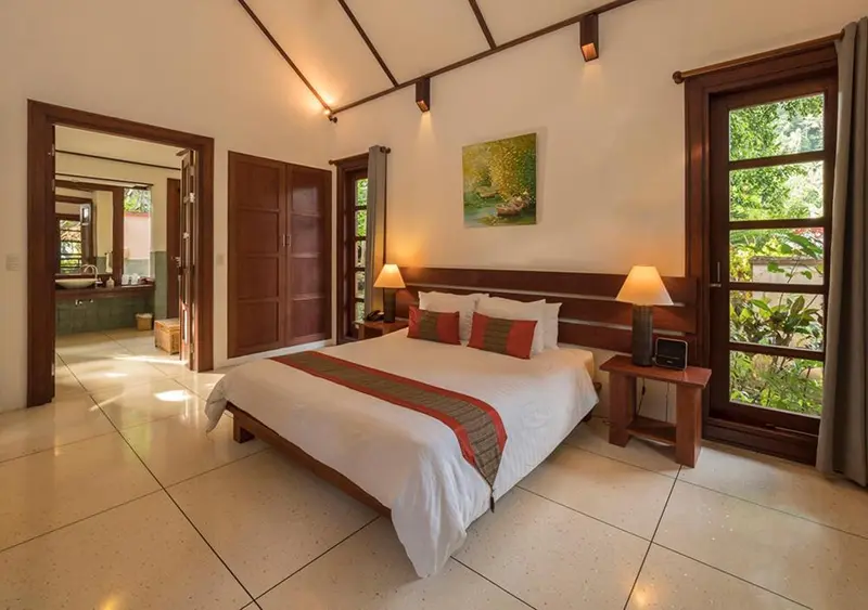 Une chambre lumineuse avec un lit double et un accès à une salle de bain.