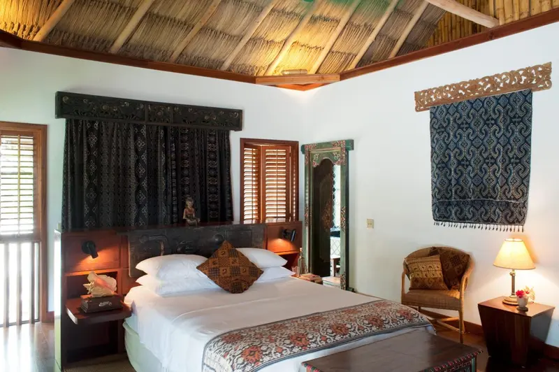 Une chambre lumineuse avec un lit recouvert d'une courtepointe décorative et des meubles en bois.