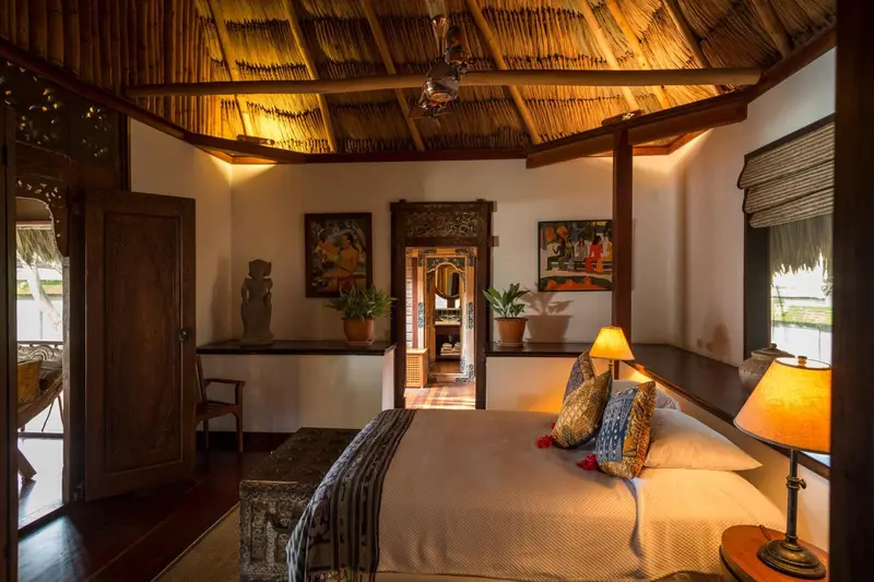 Une chambre lumineuse avec un grand lit et un accès à une salle de bain.