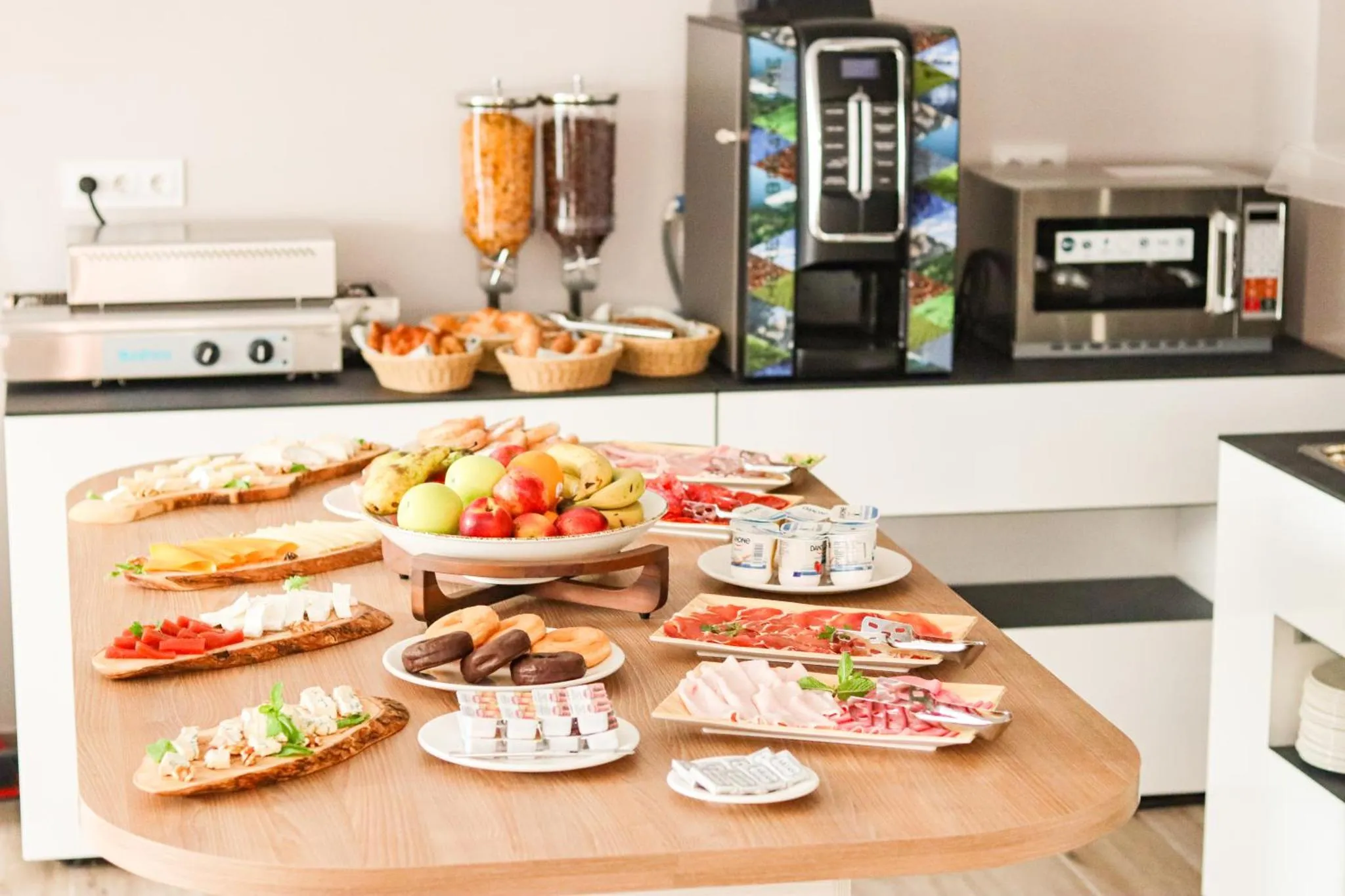Un buffet propose une variété de viennoiseries, de fruits et de charcuteries.