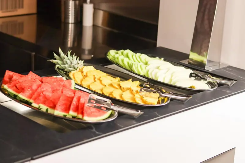 Présentation de fruits frais coupés sur un comptoir noir.