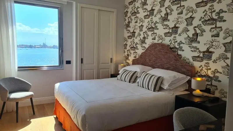 Une chambre lumineuse avec un grand lit et une vue sur la mer.