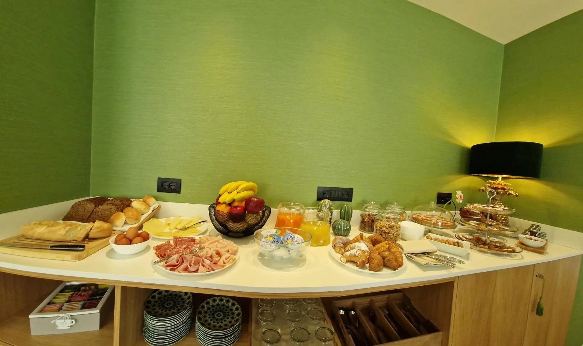 Un buffet propose des viennoiseries, des fruits et des boissons.