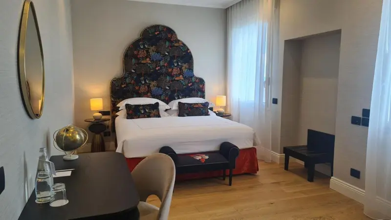 Une chambre lumineuse avec un grand lit et une décoration soignée.