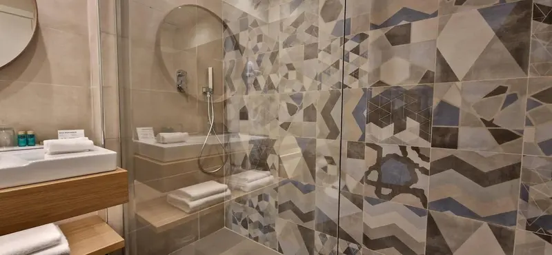 Une salle de bain moderne avec une douche à l'italienne et des carreaux décoratifs.