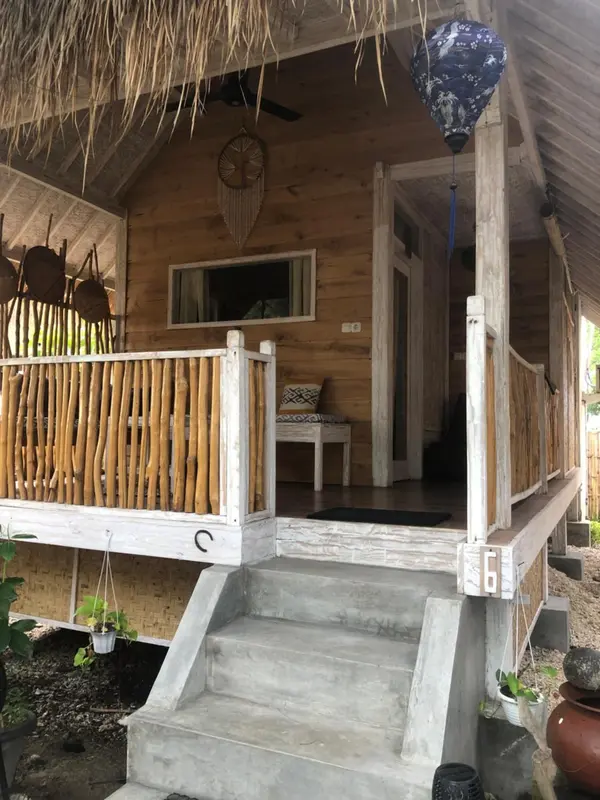 Une terrasse en bois devant une petite maison en bois.