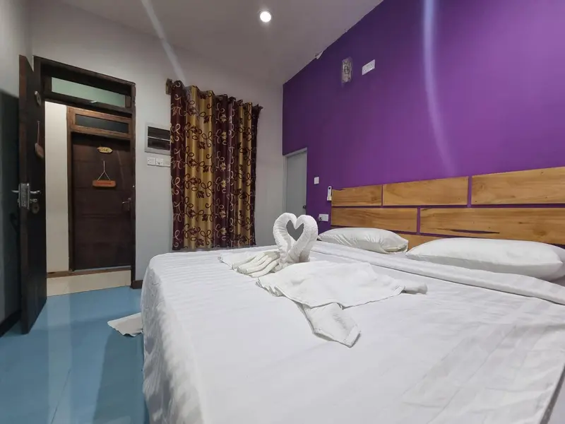 Une chambre avec un lit double décoré de serviettes en forme de cygne.