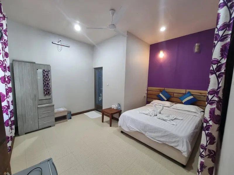 Une chambre lumineuse avec un lit double et un grand placard.