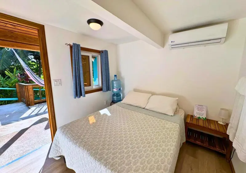 Une chambre lumineuse avec un lit et un accès à une terrasse.