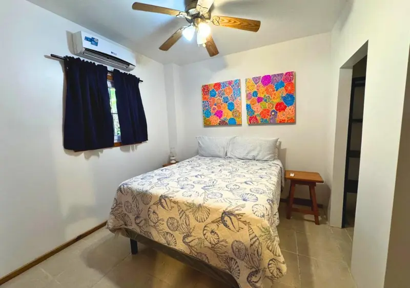 Une chambre lumineuse avec un lit recouvert d'une courtepointe à motifs.
