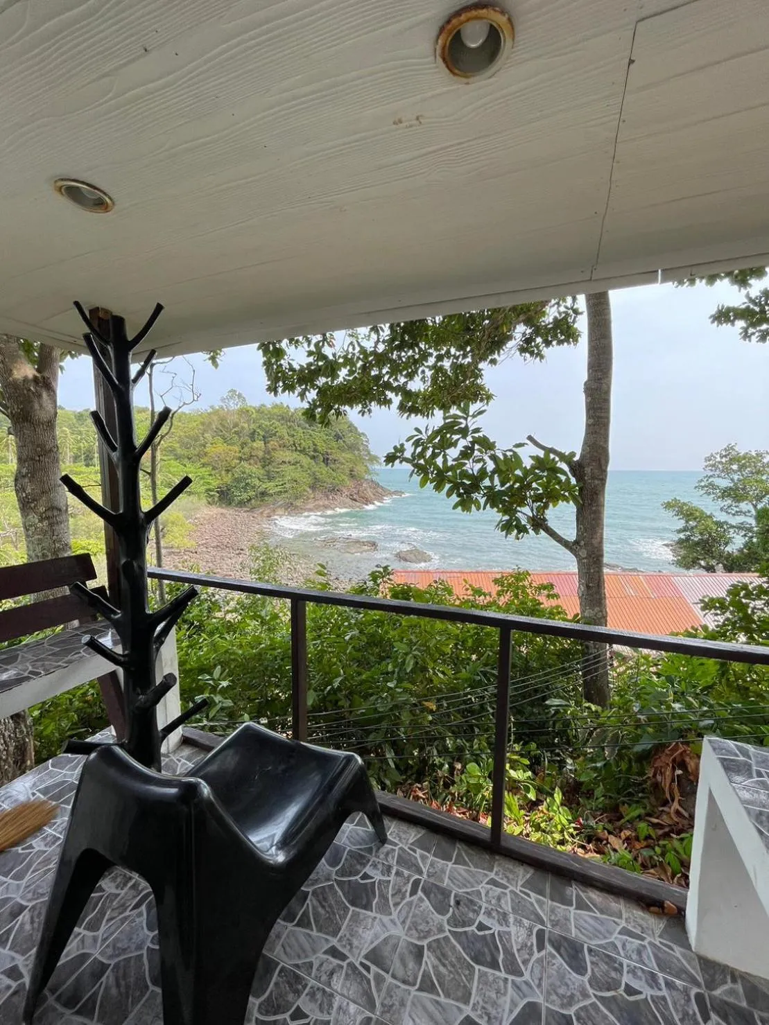 Vue sur la mer depuis une terrasse ombragée.
