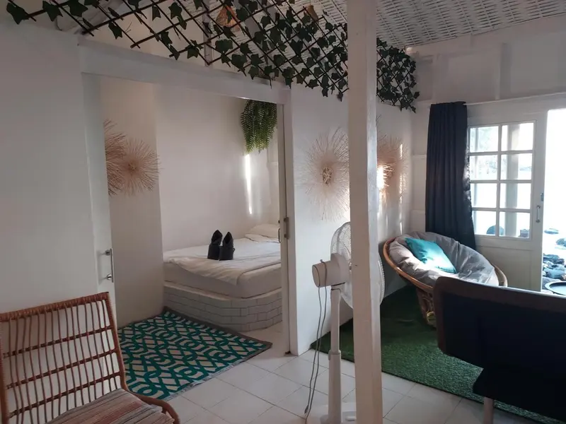 Une chambre lumineuse avec un lit et un coin salon.