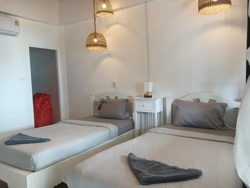 Une chambre lumineuse avec deux lits simples et une décoration sobre.