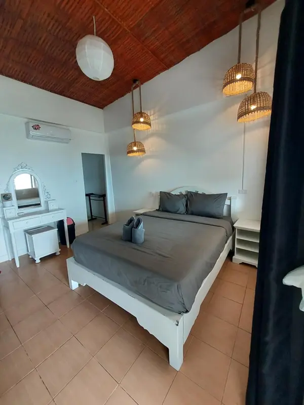 Une chambre lumineuse avec un lit double et une coiffeuse.