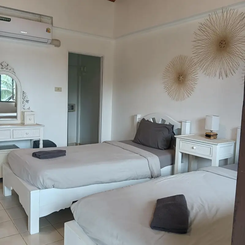 Une chambre lumineuse avec deux lits simples et une décoration murale.