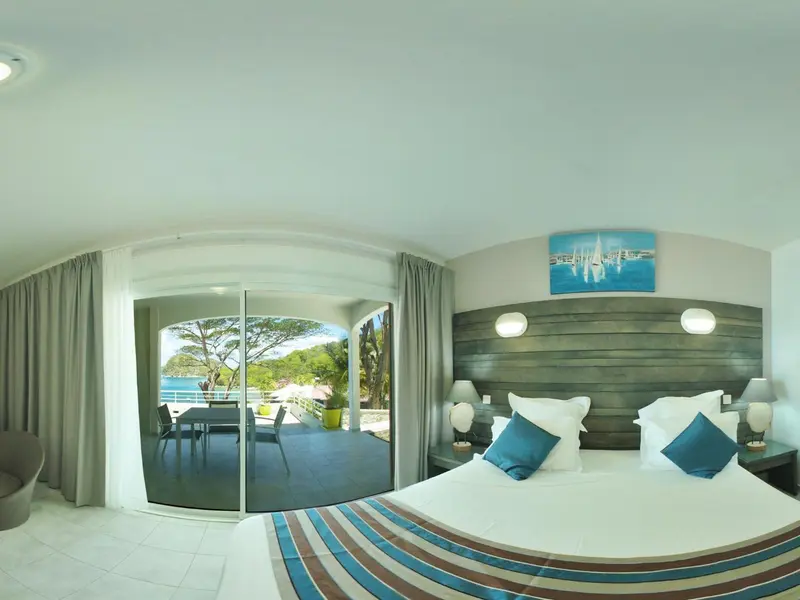 Une chambre lumineuse avec un grand lit et une vue sur la mer.