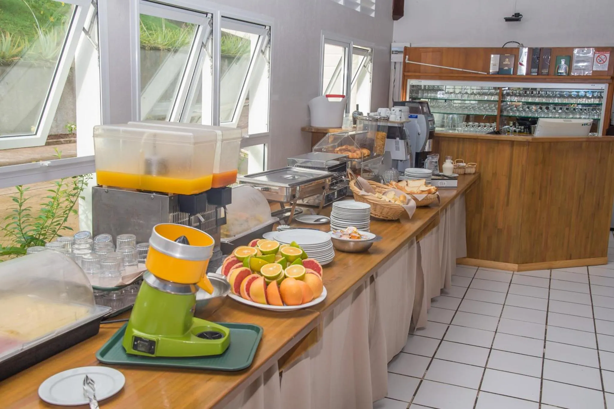 Un buffet propose des jus de fruits, des pâtisseries et des fruits frais.