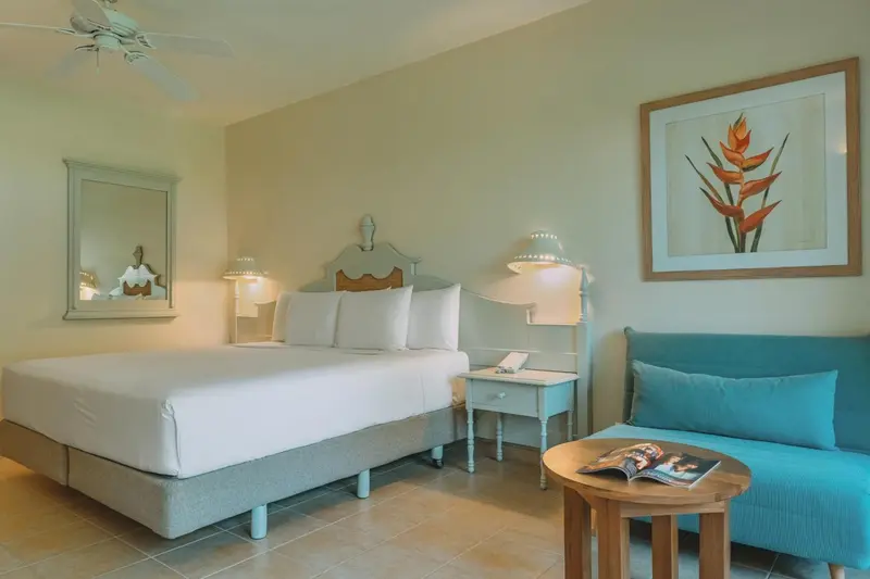 Une chambre lumineuse avec un grand lit et un coin salon.