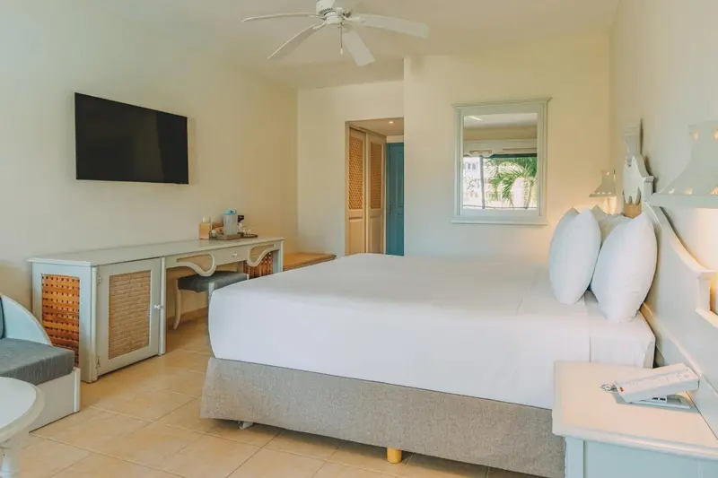 Une chambre lumineuse avec un grand lit et un bureau.
