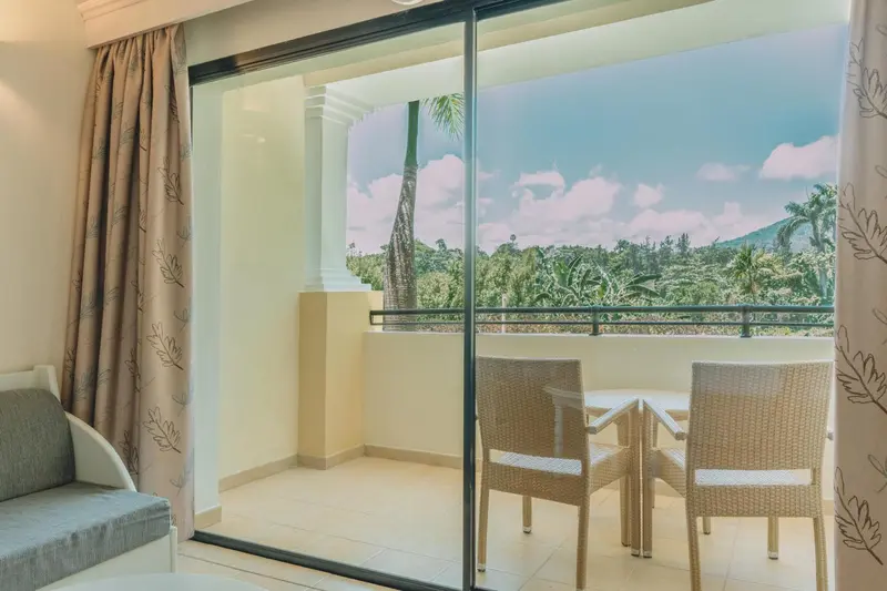 Vue sur un paysage tropical depuis un balcon aménagé.