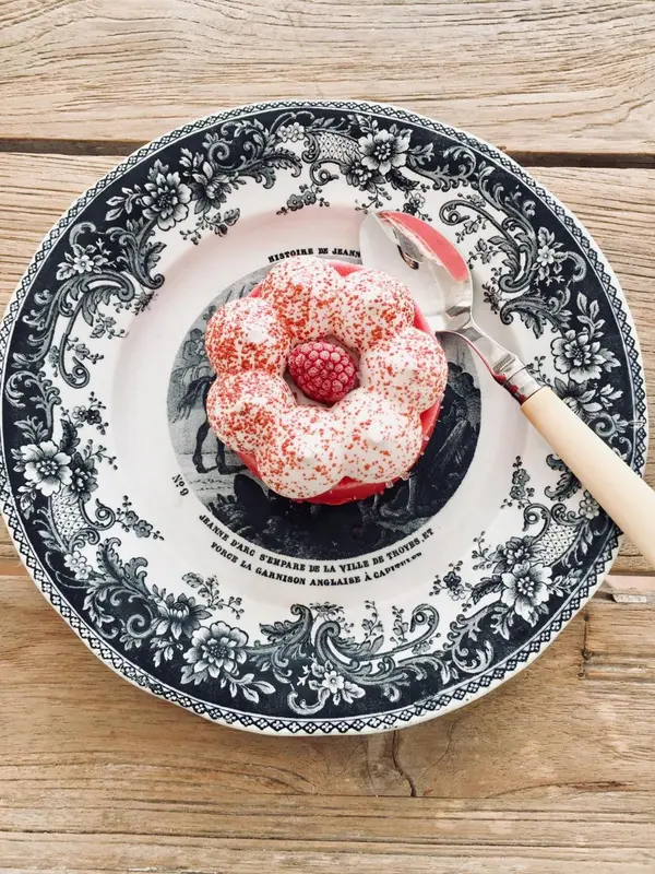 Assiette décorative avec une pâtisserie aux fruits rouges et une cuillère.