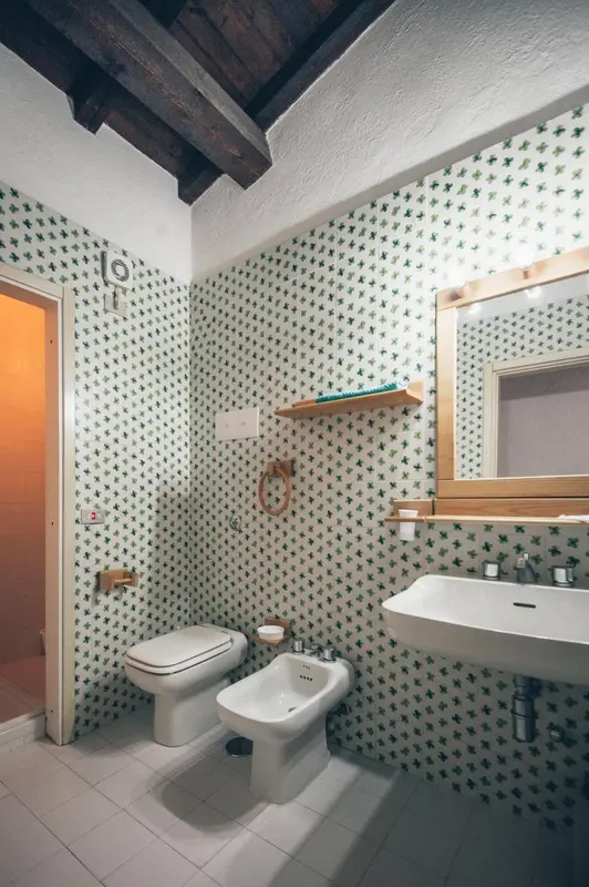 Une salle de bain claire avec des carreaux verts et blancs.