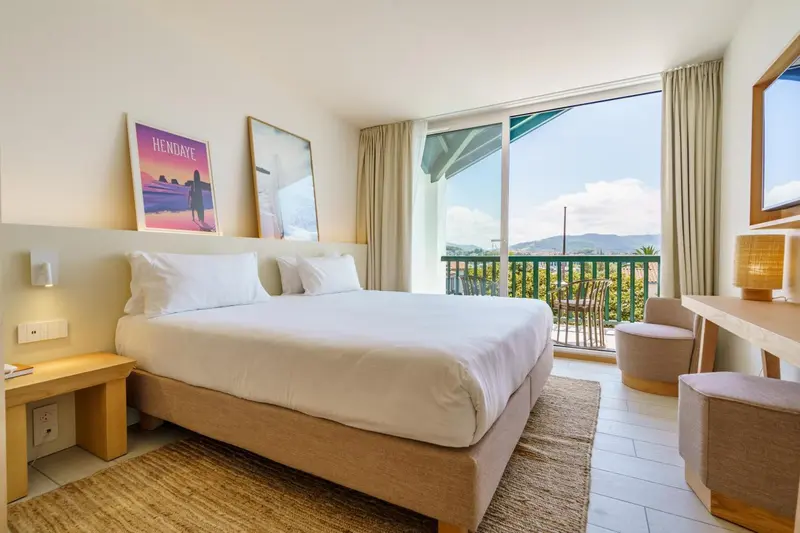 Une chambre lumineuse avec un grand lit et une vue sur la mer.