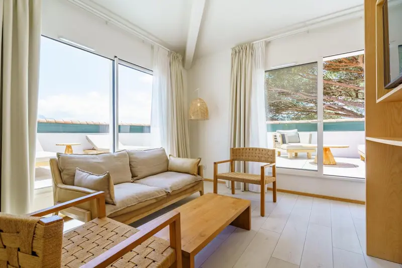 Espace de détente lumineux avec canapé et mobilier en bois clair.