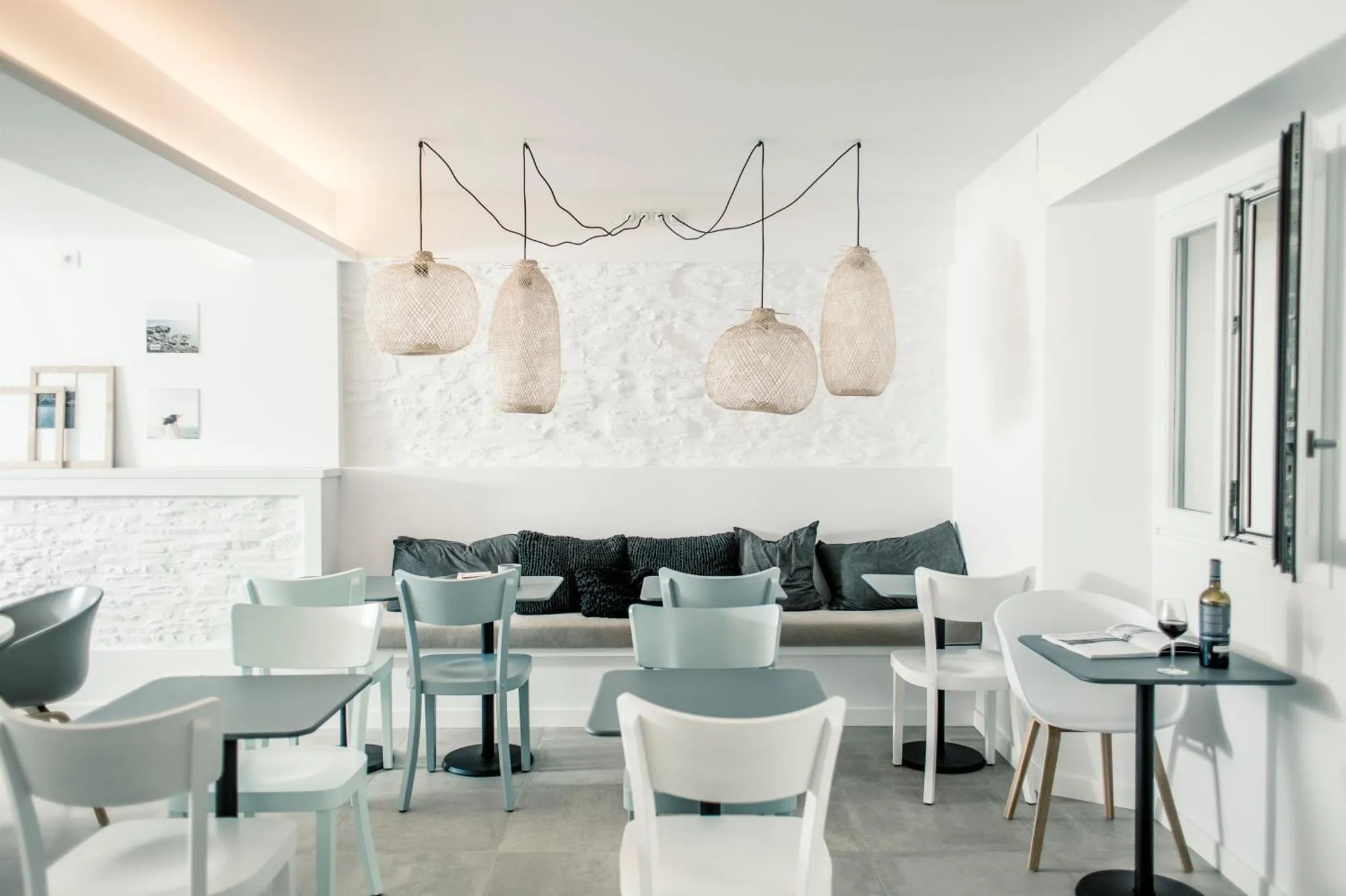 Espace de détente intérieur avec tables basses et luminaires suspendus.
