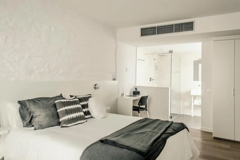 Une chambre lumineuse avec un grand lit et un espace bureau.