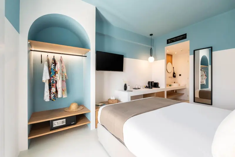 Une chambre lumineuse avec un lit et un espace rangement ouvert.