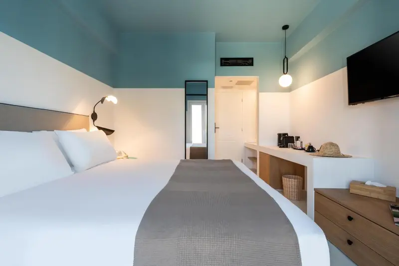 Une chambre lumineuse avec un grand lit et un espace détente.