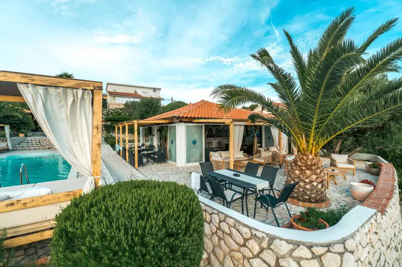 Espace extérieur aménagé avec piscine, mobilier de jardin et végétation luxuriante.