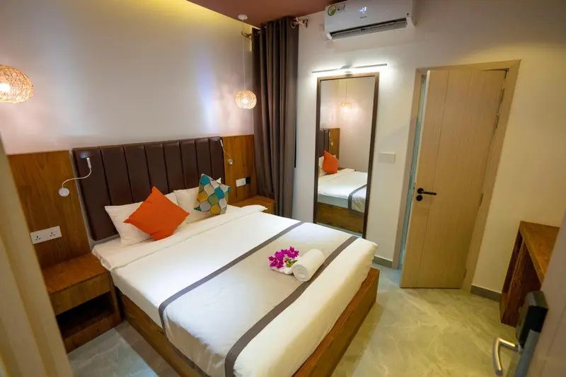 Une chambre lumineuse avec un lit double et des tables de chevet.