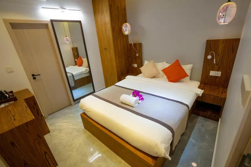 Une chambre lumineuse avec un grand lit et un miroir.