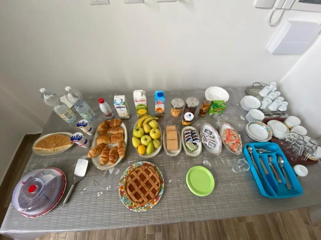 Une table recouverte de viennoiseries, de fruits et de boissons.