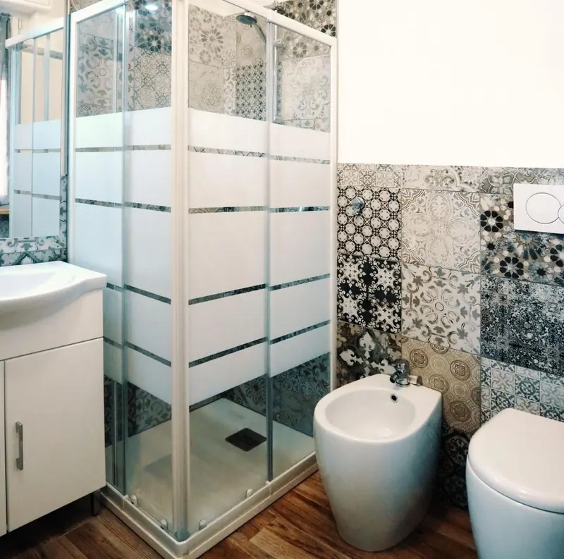 Une salle de bain moderne avec douche à l'italienne et sanitaires blancs.