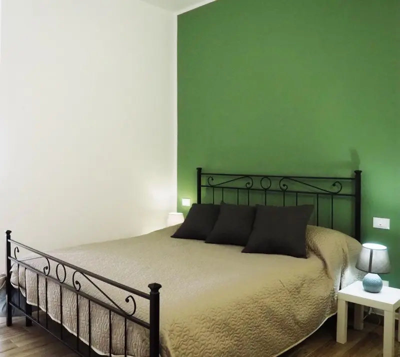 Une chambre avec un lit double et une décoration sobre.