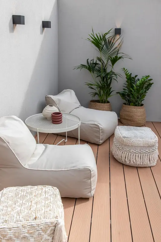Espace de détente extérieur avec assises confortables et plantes.