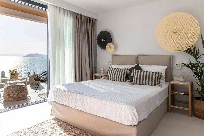 Une chambre lumineuse avec un grand lit et une vue sur la mer.