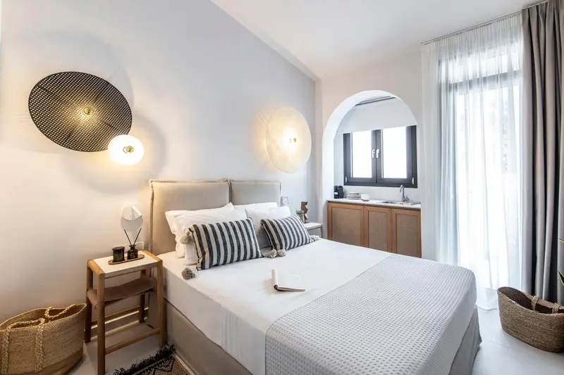Une chambre lumineuse avec un grand lit et une décoration sobre.