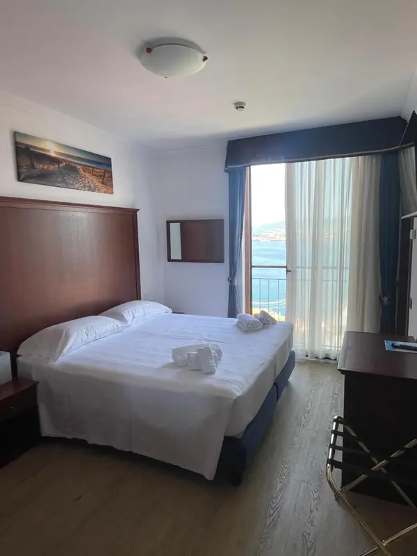 Une chambre lumineuse avec un grand lit et une vue sur la mer.