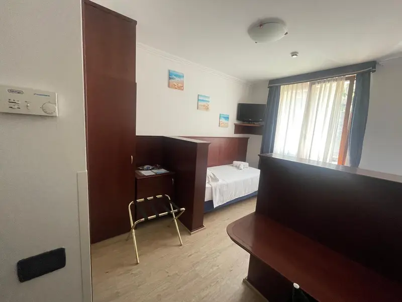 Une chambre lumineuse avec un lit simple et un espace détente.