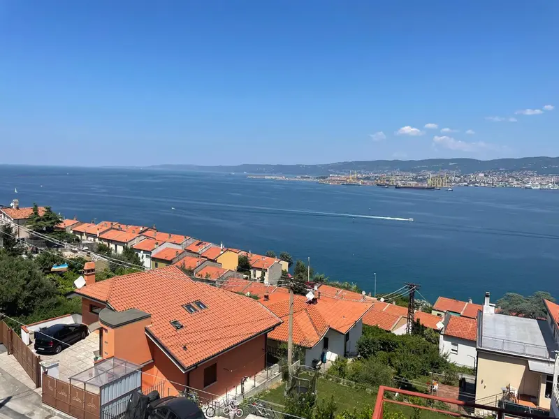 Vue aérienne sur des toits en tuiles oranges et la mer bleue.