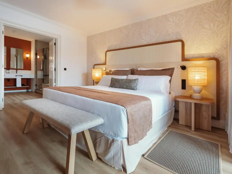Une chambre lumineuse avec un grand lit et une décoration sobre.