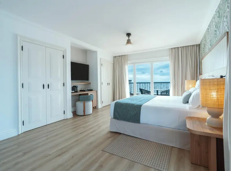Une chambre lumineuse avec un grand lit et une vue sur la mer.